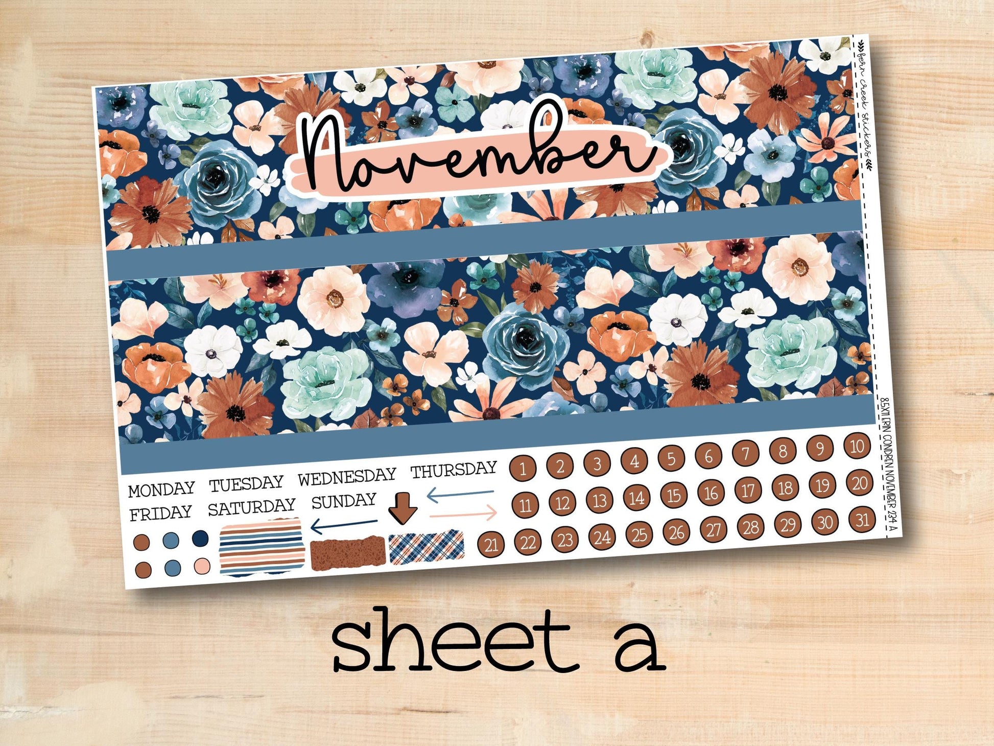 a wooden table topped with a blue and orange flowered calendar