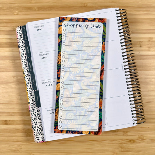 a notebook with a shopping list on top of it