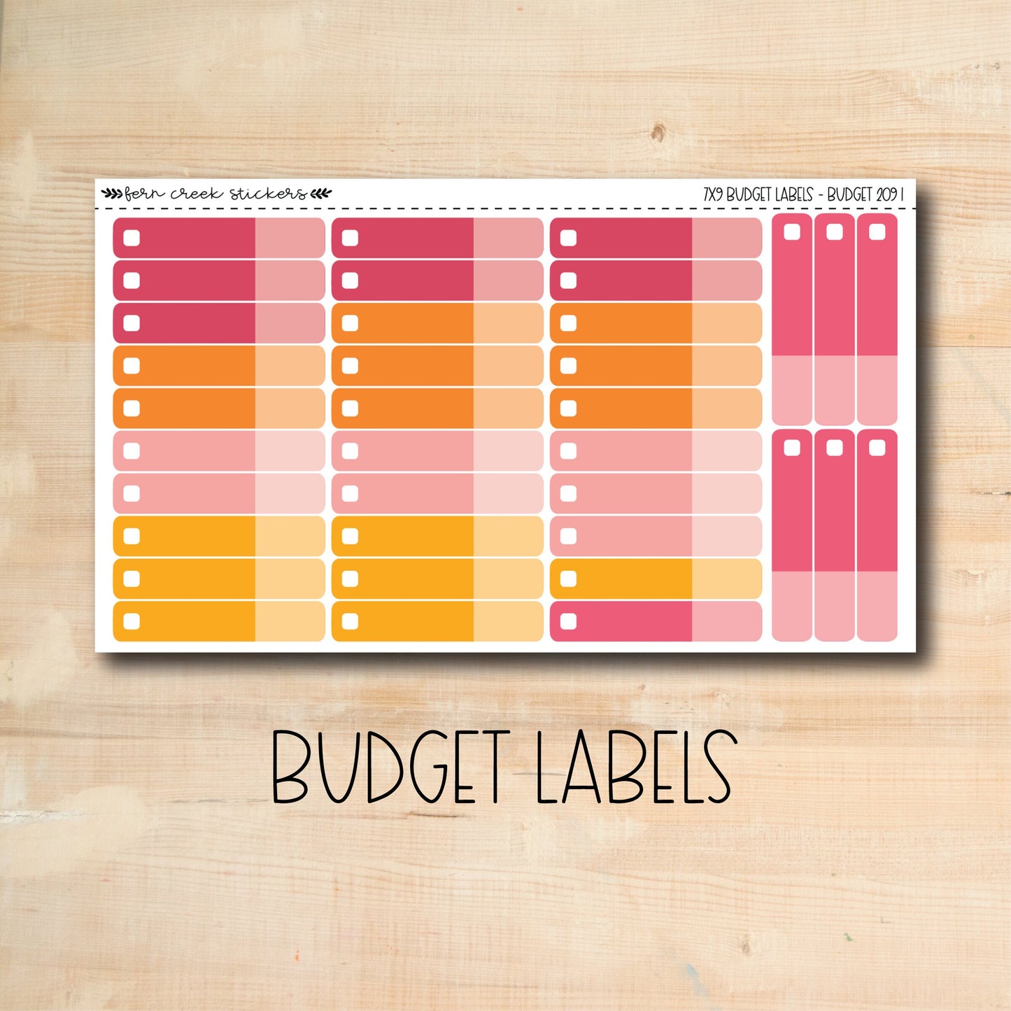 a pink and orange planner sticker on a wooden surface