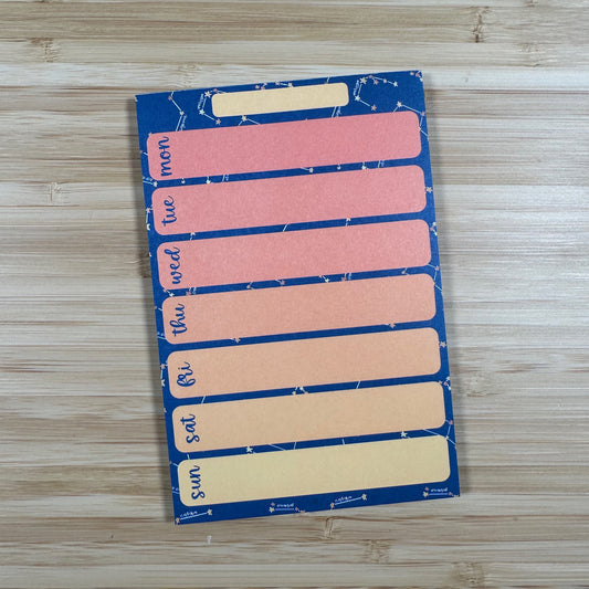 a pink and blue sticker on a wooden surface